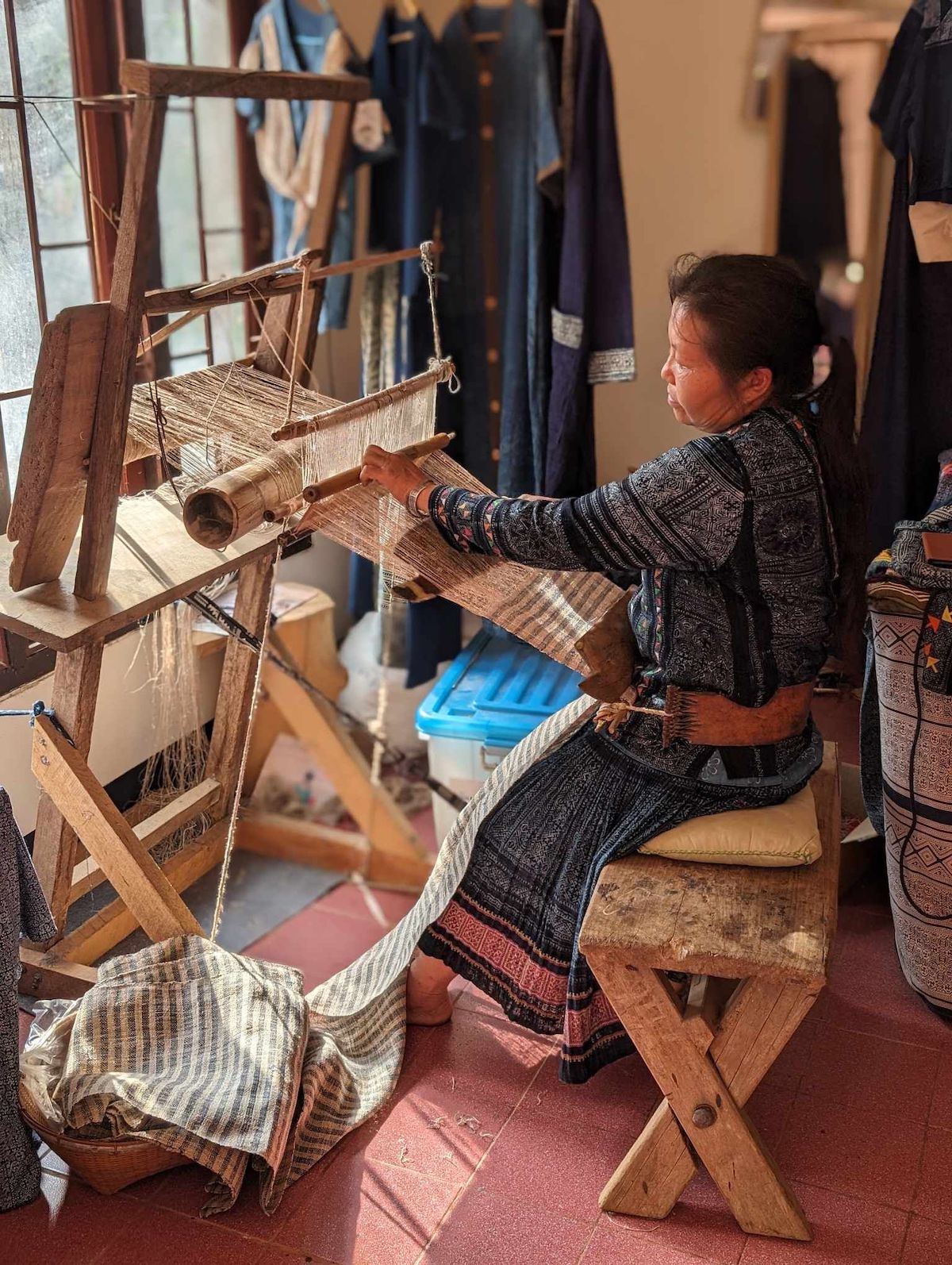 A Hill Tribe woman in Thailand weaving handwoven hemp fabric on a loom.